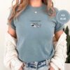 Person wearing an ice blue Open-Mouthed Gray Shark Embroidered T-Shirt