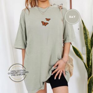 Person wearing a bay Orange Butterflies Embroidered T-Shirt