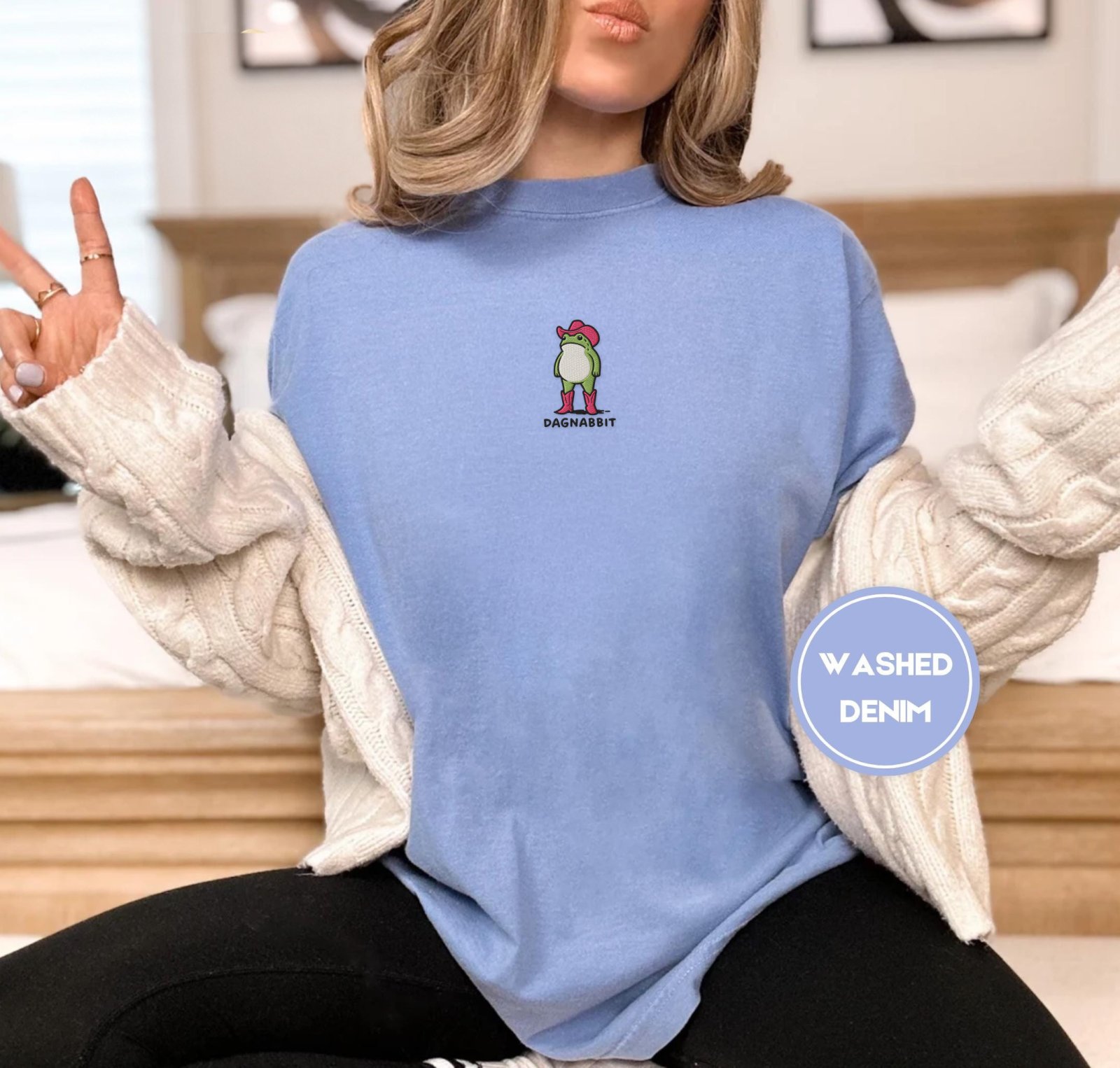 Person wearing a washed denim Pink Boots Cowboy Frog Embroidered T-Shirt