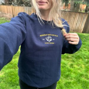Person wearing a navy Puget Sound Orcas Embroidered Sweatshirt