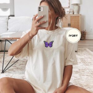 Person wearing an ivory Purple Butterfly Embroidered T-Shirt