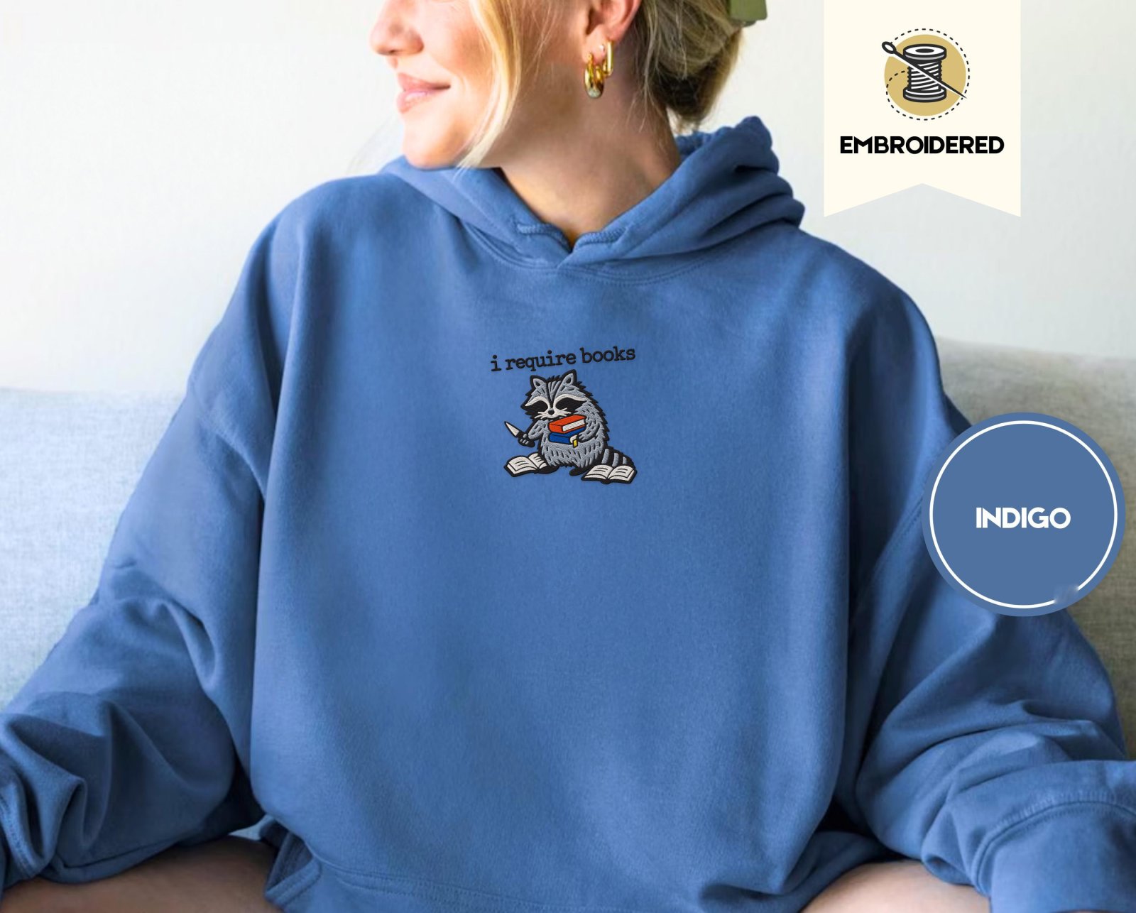 Person wearing an indigo blue Raccoon and Open Books Embroidered Hoodie