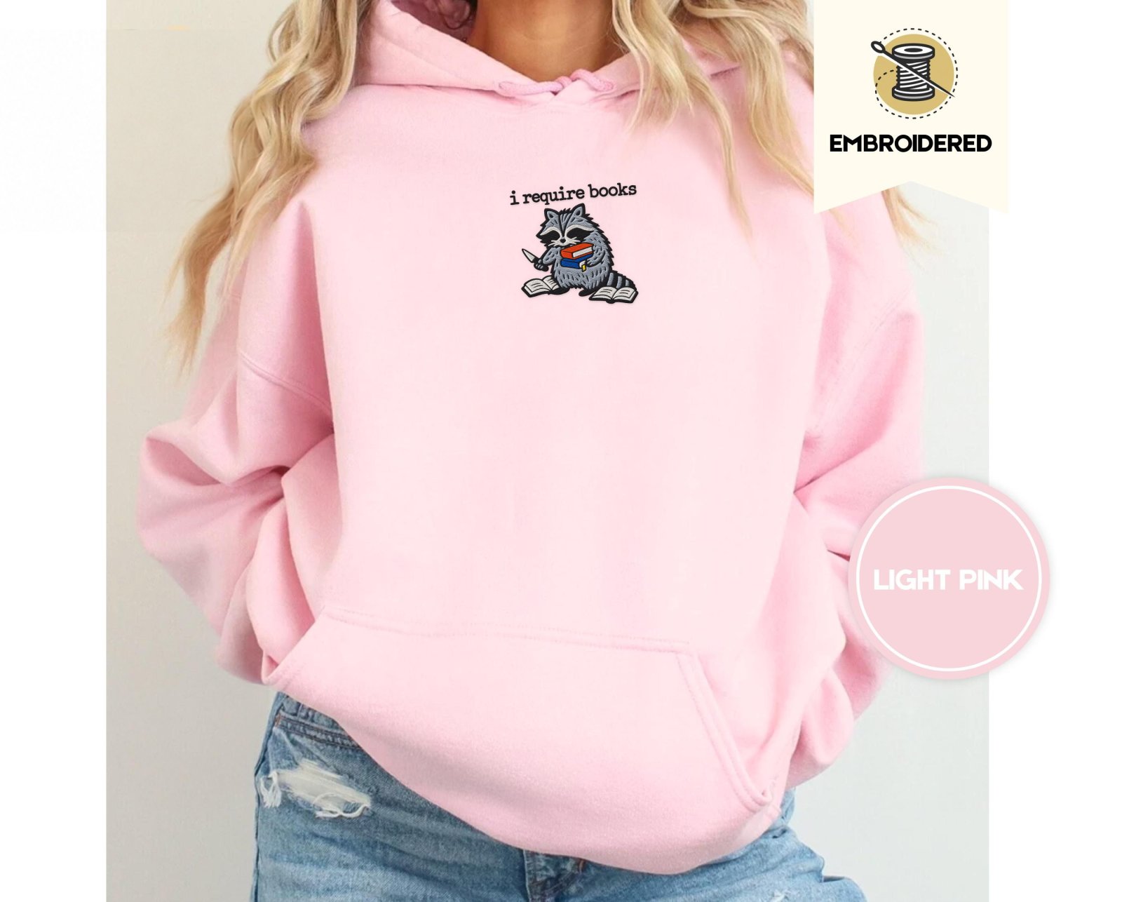 Person wearing a light pink Raccoon and Open Books Embroidered Hoodie