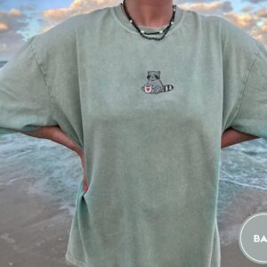 Person wearing a bay Raccoon Coffee Cup Embroidered T-Shirt