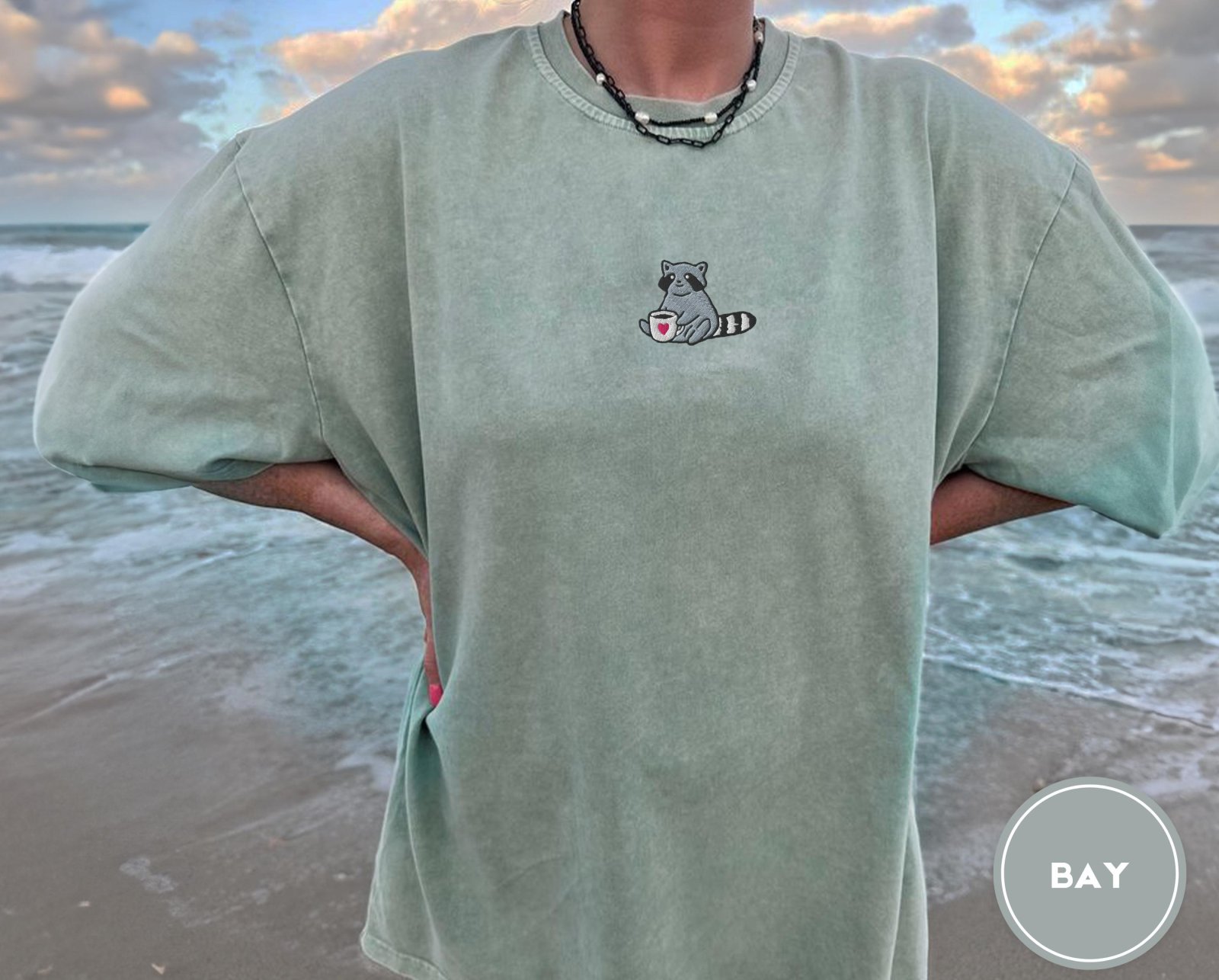 Person wearing a bay Raccoon Coffee Cup Embroidered T-Shirt
