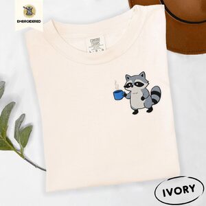 Ivory Raccoon Holding Blue Coffee Mug Embroidered T-Shirt
