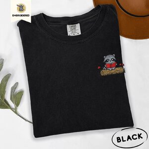 Black Raccoon Reading on Log Embroidered T-Shirt