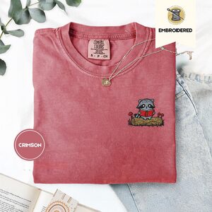Crimson Raccoon Reading on Log Embroidered T-Shirt