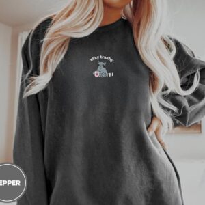 Person wearing a pepper Raccoon With Heart Mug Embroidered T-Shirt