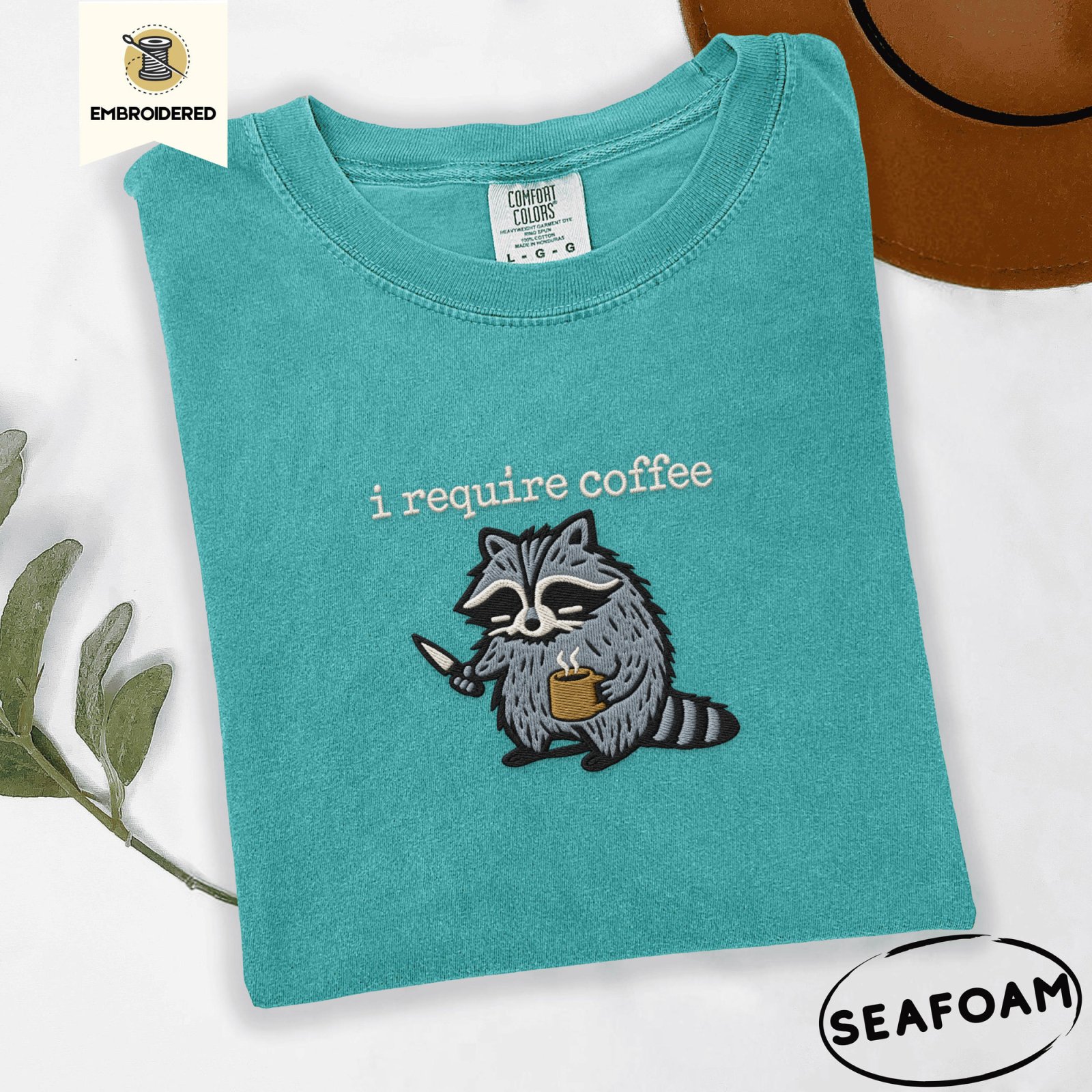 Seafoam Raccoon With Knife and Mug Embroidered T-Shirt