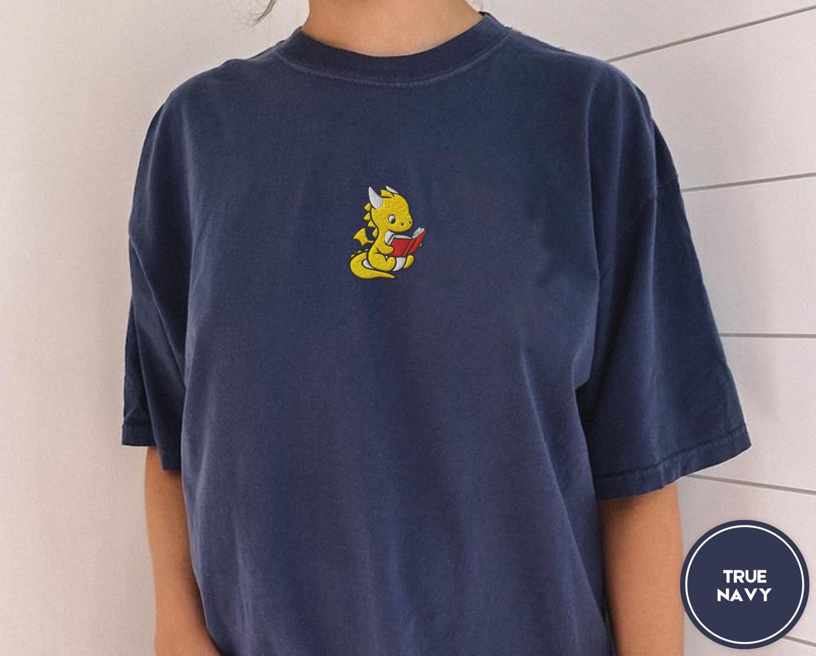 Person wearing a true navy Reading Dragon Embroidered T-Shirt