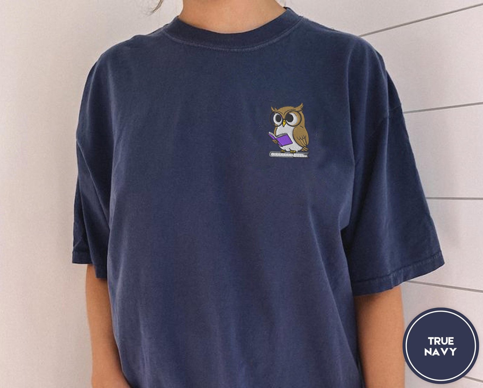 Person wearing a true navy Reading Owl Embroidered T-Shirt