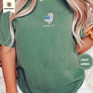 Person wearing a light green Reading Polar Bear Embroidered T-Shirt