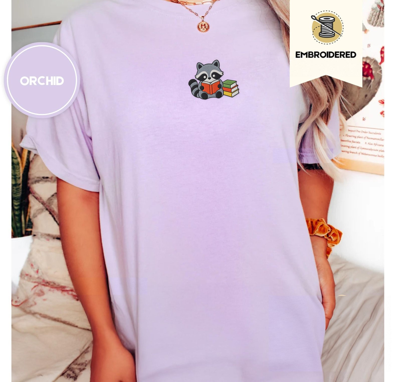 Person wearing an orchid Reading Raccoon Embroidered T-Shirt