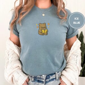Person wearing an ice blue Reading Teddy Bear Embroidered T-Shirt