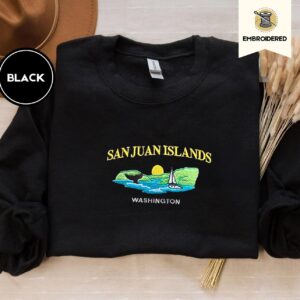 Black crewneck sweatshirt embroidered with San Juan Islands, Washington, an orca tail, a sailboat and a setting sun