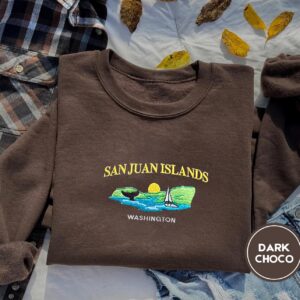 Dark Chocolate crewneck sweatshirt embroidered with San Juan Islands, Washington, an orca tail, a sailboat and a setting sun