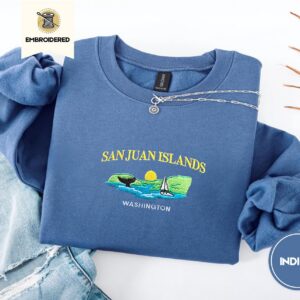 Indigo Blue crewneck sweatshirt embroidered with San Juan Islands, Washington, an orca tail, a sailboat and a setting sun