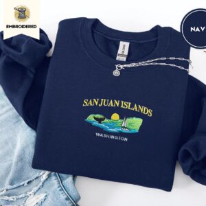 Navy crewneck sweatshirt embroidered with San Juan Islands, Washington, an orca tail, a sailboat and a setting sun