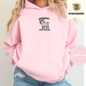 Person wearing a light pink Screaming Goat Embroidered Hoodie