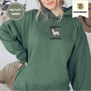 Person wearing a military green Screaming Goat Embroidered Hoodie