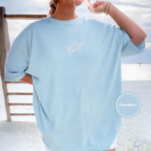Person wearing a chambray Sea Turtle Embroidered T-Shirt