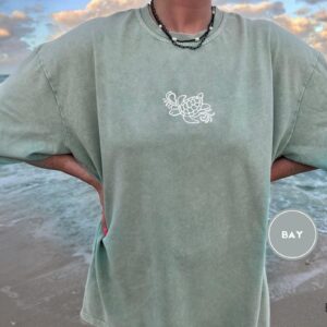 Person wearing a bay Sea Turtle Waves Embroidered T-Shirt