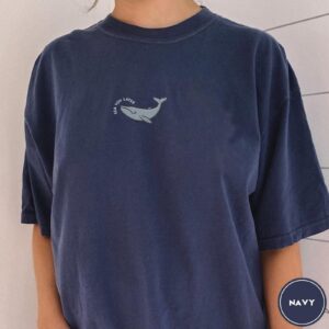 Person wearing a navy Sea You Later Whale Embroidered T-Shirt