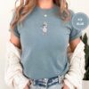 Person wearing an ice blue Self-Care Goose Embroidered T-Shirt