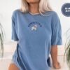 Person wearing a blue jean Sensitive Lamb Embroidered T-Shirt