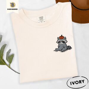 Ivory Sitting Raccoon With Pumpkin Hat Embroidered T-Shirt