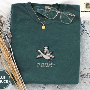 Blue Spruce Situations Quote Raccoon and Goose Embroidered T-Shirt