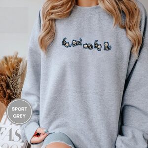Person wearing a sport grey Skeleton Cats Embroidered Sweatshirt