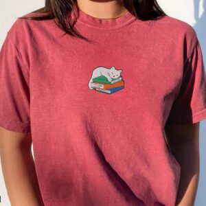 Person wearing a brick Sleeping Cat on Books Embroidered T-Shirt