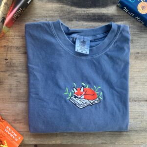Flat lay of the Sleeping Fox on Book Embroidered T-Shirt