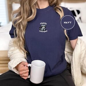 Person wearing a navy Slightly Unhinged Raccoon Embroidered T-Shirt