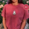 Person wearing a brick Snowy Owl on Bookstack Embroidered T-Shirt