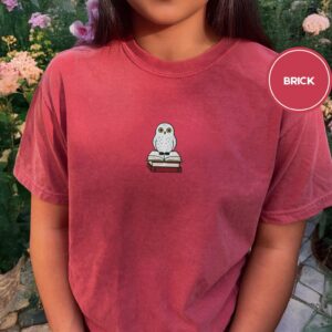 Person wearing a brick Snowy Owl on Bookstack Embroidered T-Shirt