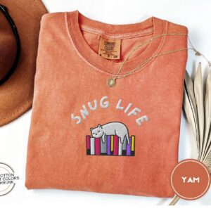 Flat lay of the Snug Life Cat and Books Embroidered T-Shirt