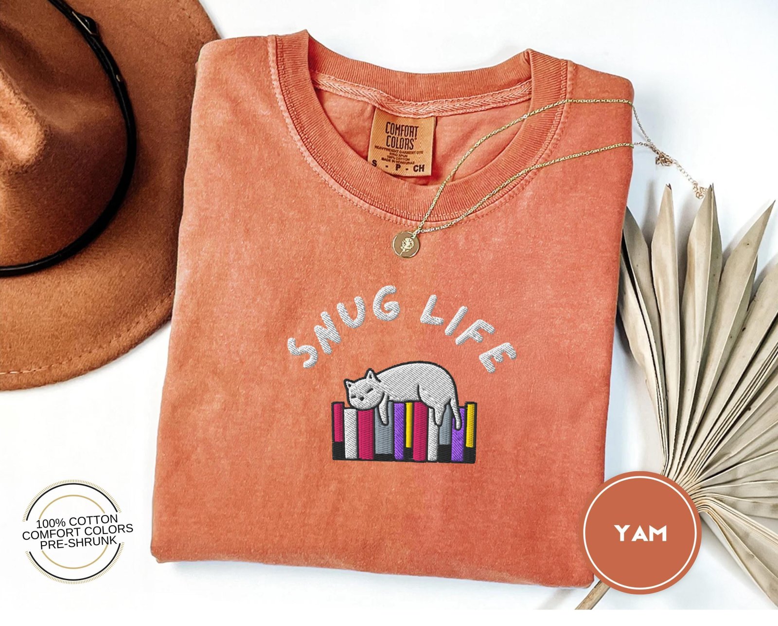 Flat lay of the Snug Life Cat and Books Embroidered T-Shirt