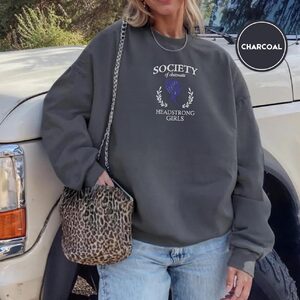 Person wearing a charcoal Society of Obstinate Headstrong Girls Embroidered Sweatshirt