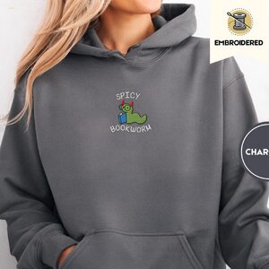 Person wearing a charcoal Spicy Bookworm Embroidered Hoodie
