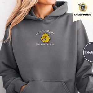 Person wearing a charcoal Stability Duck Embroidered Hoodie