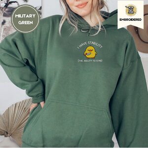 Person wearing a military green Stability Duck Embroidered Hoodie