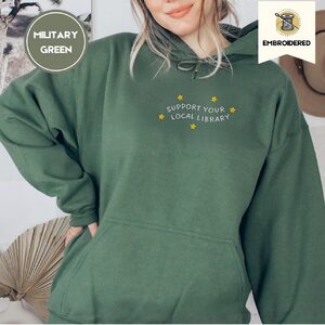 Person wearing a military green Support Your Local Library Embroidered Hoodie