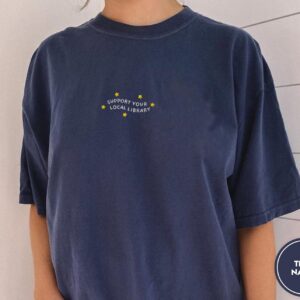 Person wearing a true navy Support Your Local Library Embroidered T-Shirt