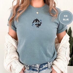 Person wearing an ice blue Two Orcas and Blue Stars Embroidered T-Shirt