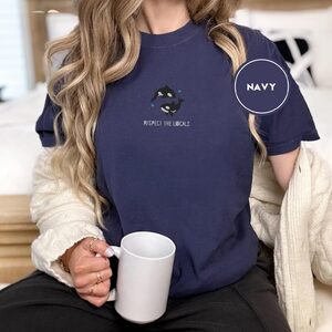 Person wearing a navy Two Orcas and Blue Stars Embroidered T-Shirt