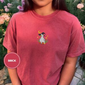 Person wearing a brick Witchy Duckling Embroidered T-Shirt