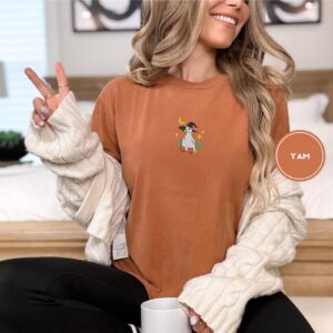 Person wearing a yam Witchy Duckling Embroidered T-Shirt